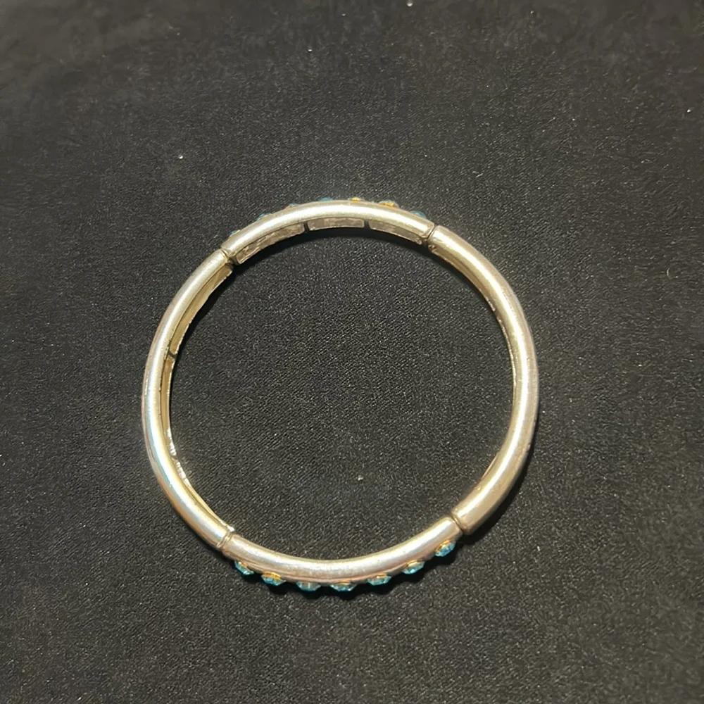 Kids silver bracelet with 7 blue rhinestones each side of bracelet. Gently used